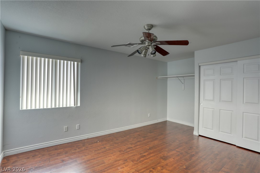 7226 Cestrum Road Las Vegas, NV 89113 - Photo 15 of 28 Unfurnished bedroom featuring dark wood-type flooring, ceiling fan, and a closet