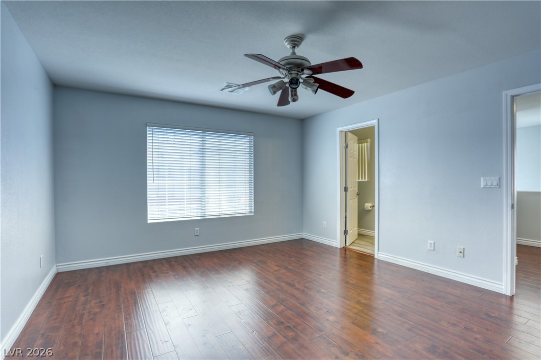 7226 Cestrum Road Las Vegas, NV 89113 - Photo 22 of 28 Second bedroom with dark wood finished floors, a ceiling fan, and ensuite bath