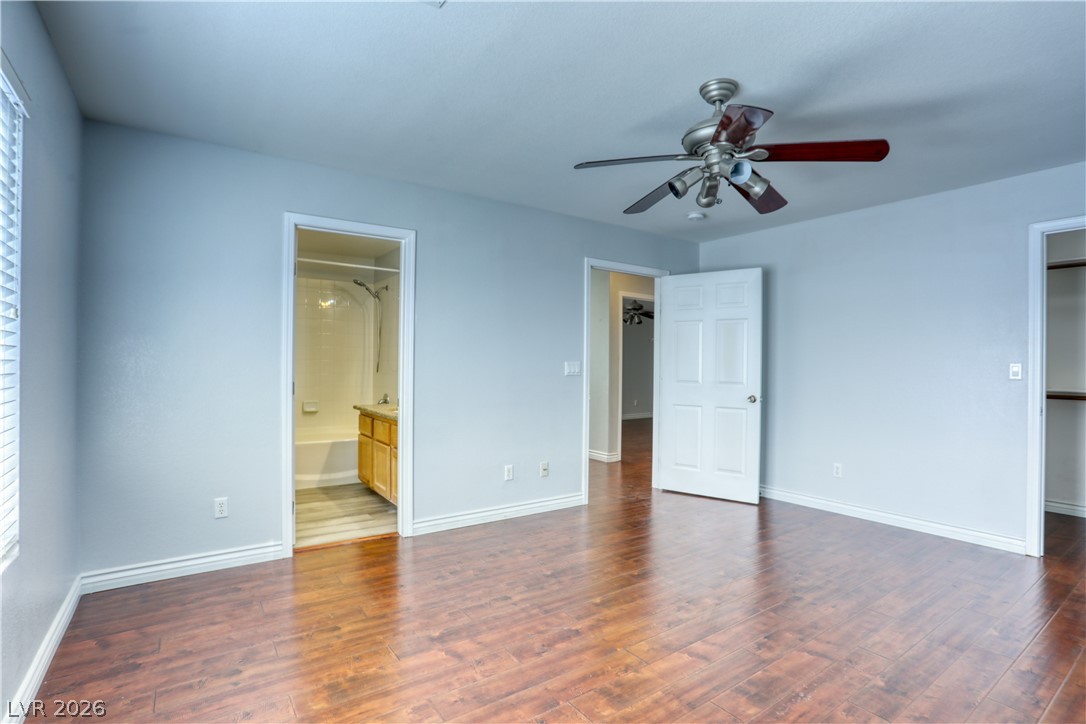 7226 Cestrum Road Las Vegas, NV 89113 - Photo 23 of 28 bedroom featuring dark wood finished floors, multiple windows, a spacious closet, and ensuite bath