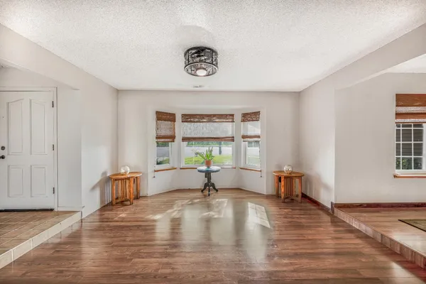 a kitchen with kitchen island stainless steel appliances a dining table chairs and wooden floor