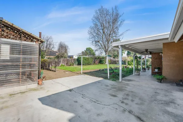 a view of house in front of a big yard with potted plants