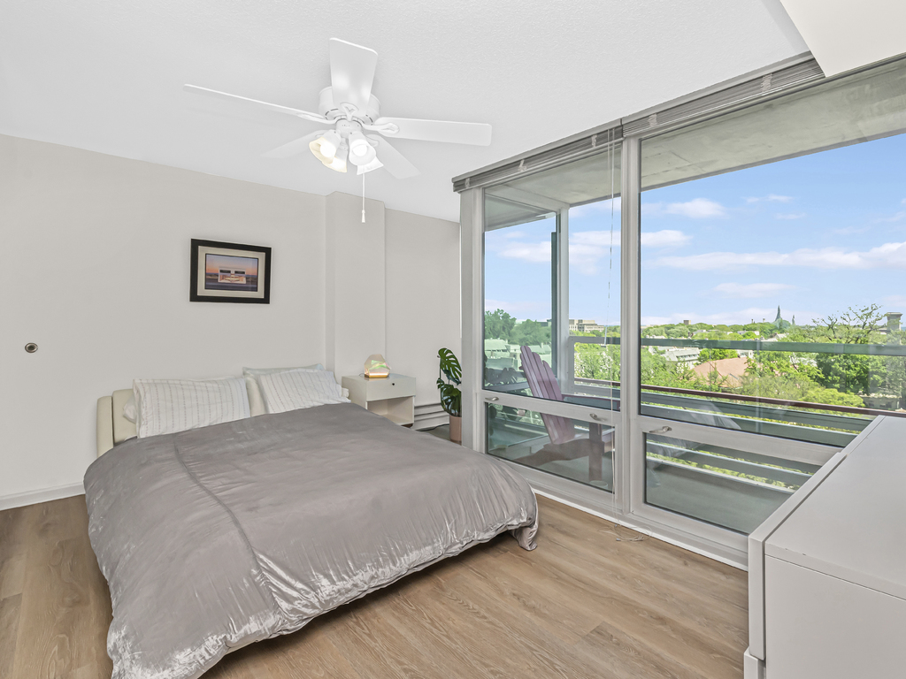 800 Elgin Road, Unit 907 Evanston, IL 60201 - Photo 10 of 17 a bedroom with a large window and a bed