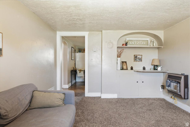 565 East 800 North Logan, UT 84321 - Photo 23 of 27 Living area featuring plush carpeting and a built-in arched alcove with shelving and cabinetry