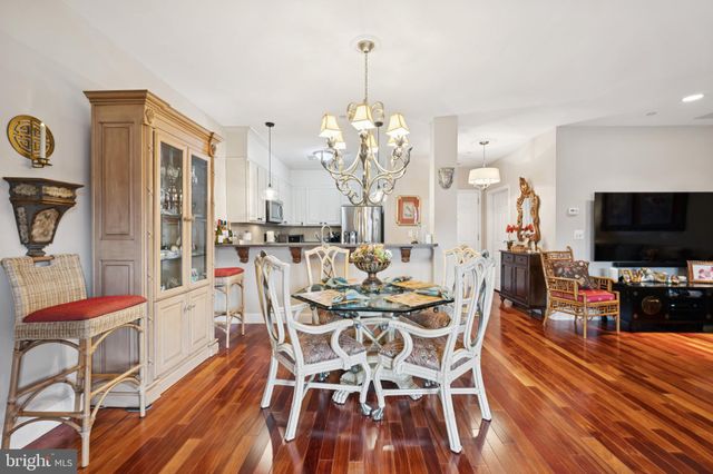 a view of a dining room with furniture a chandelier and wooden floor
