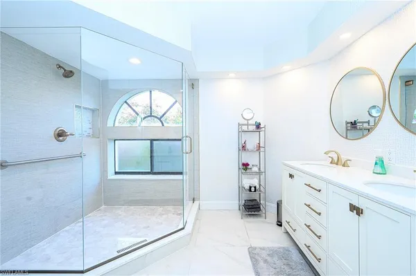 a bathroom with a mirror sink and glass door
