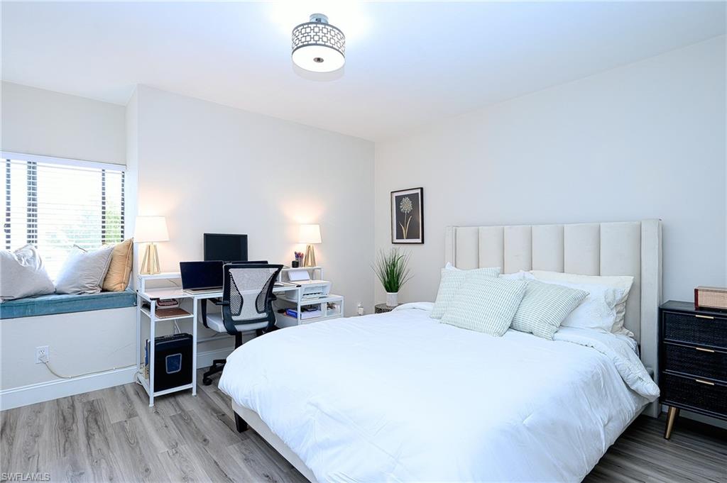586 Beachwalk Circle, Unit O205 Naples, FL 34108 - Photo 19 of 36 a bedroom with a bed and a flat screen tv