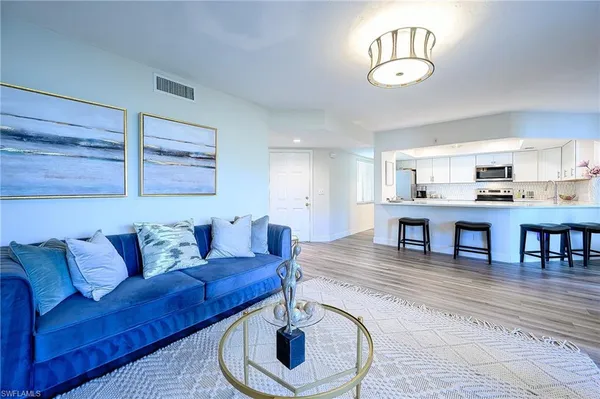 a living room with furniture and kitchen view