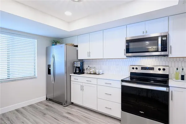 a kitchen with stainless steel appliances a stove microwave and sink