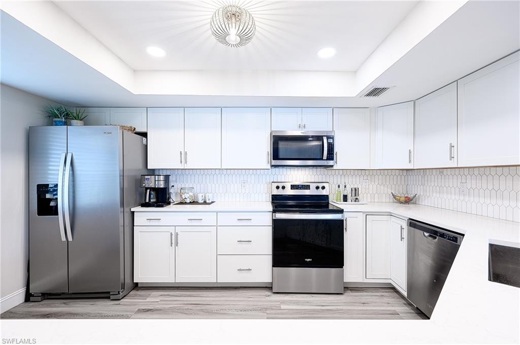 586 Beachwalk Circle, Unit O205 Naples, FL 34108 - Photo 6 of 36 a kitchen with a sink stainless steel appliances and cabinets