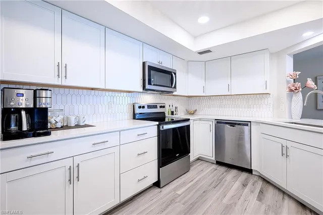 a kitchen with granite countertop white cabinets and white appliances