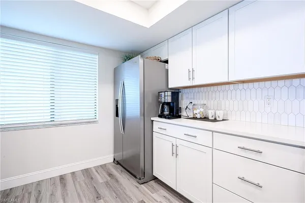a kitchen with granite countertop white cabinets and white appliances