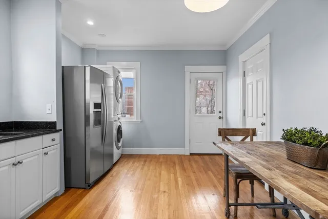 a kitchen with granite countertop white cabinets and stainless steel appliances