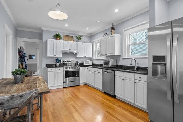 a kitchen with granite countertop a refrigerator stove top oven and sink