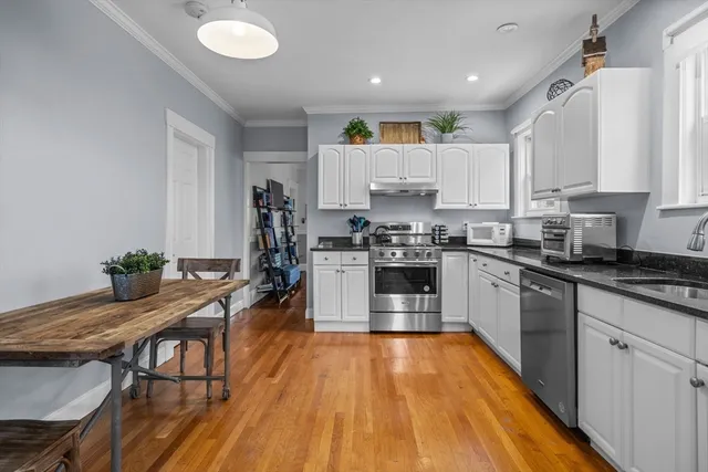 a kitchen with kitchen island granite countertop wooden floors stove and sink