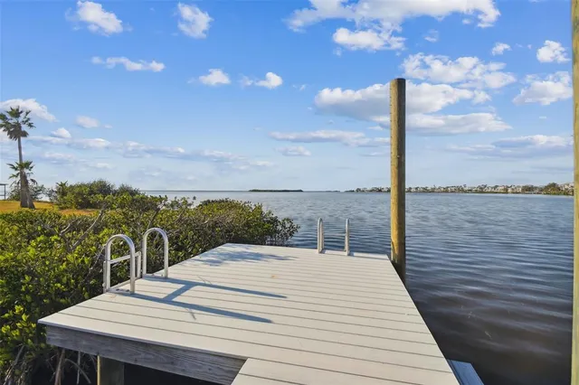 a view of a lake with a yard from a patio