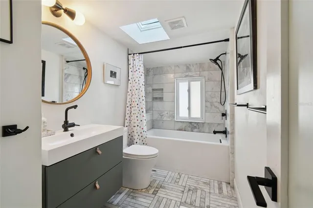 a bathroom with a sink toilet and shower a mirror