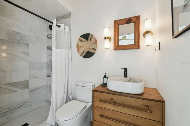 a bathroom with a sink mirror vanity and toilet