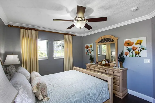 a spacious bedroom with a bed a chandelier and a dresser