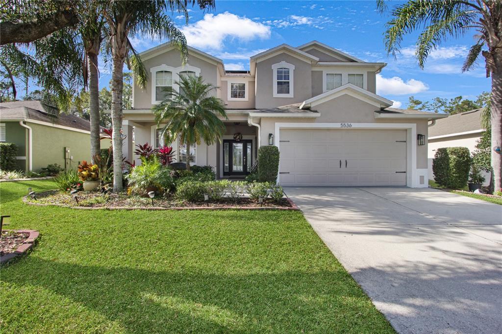 5536 Ansley Way Mount Dora, FL 32757 - Photo 49 of 49 a front view of a house with a garden and yard