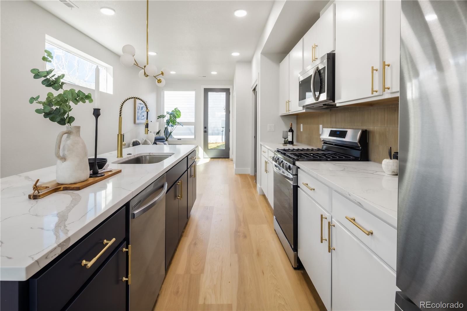 1343 Perry Street Denver, CO 80204 - Photo 16 of 37 a kitchen with kitchen island granite countertop a sink a counter space cabinets and stainless steel appliances