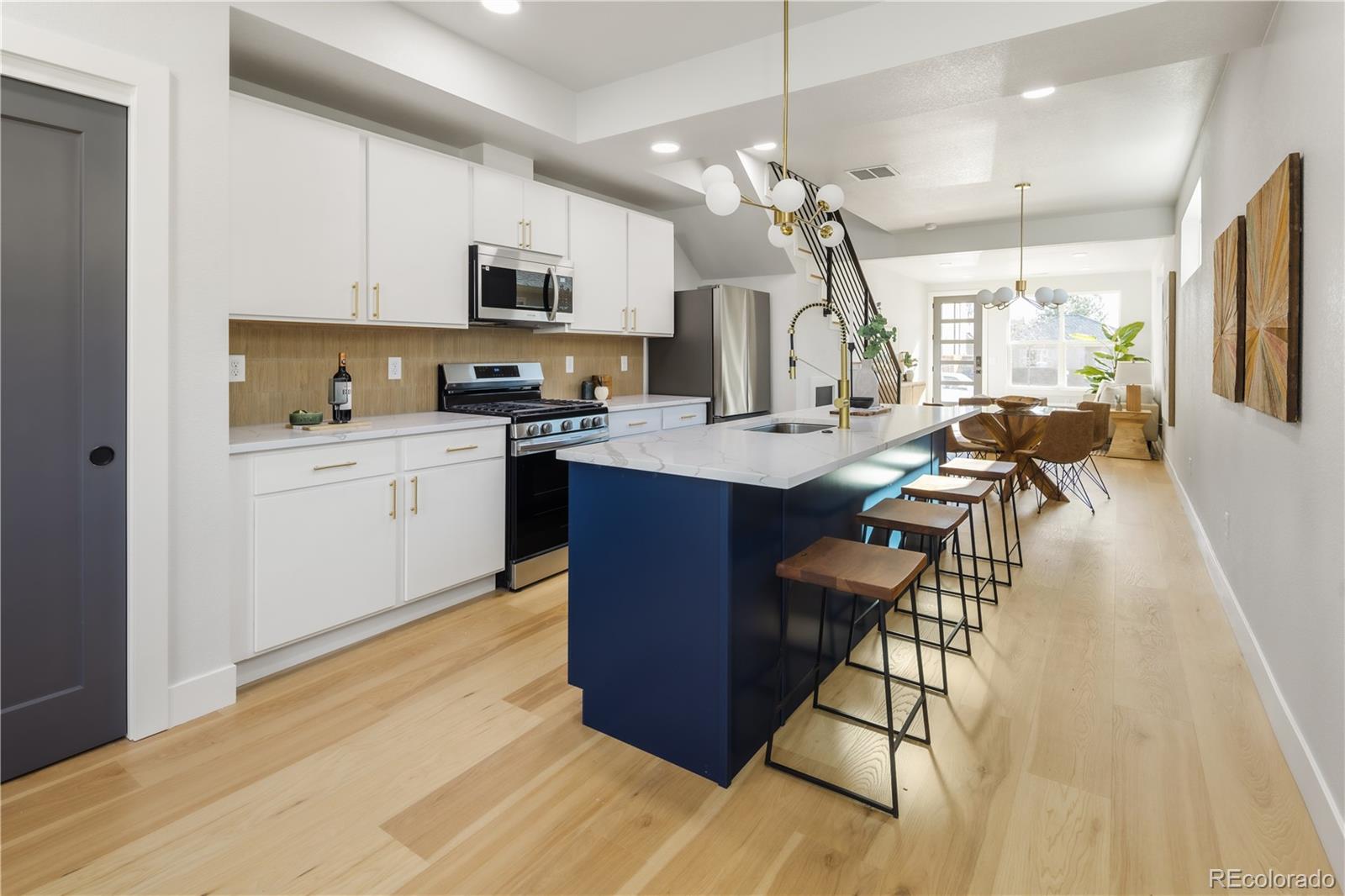 1343 Perry Street Denver, CO 80204 - Photo 19 of 37 a kitchen with stainless steel appliances granite countertop a stove top oven a sink dishwasher a dining table and chairs with wooden floor