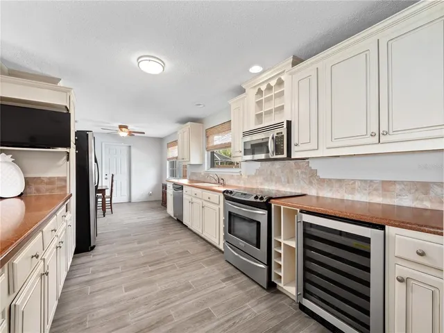 a large kitchen with stainless steel appliances granite countertop lots of counter space and wooden floor