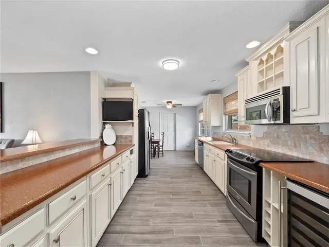 a large kitchen with stainless steel appliances and a large counter top