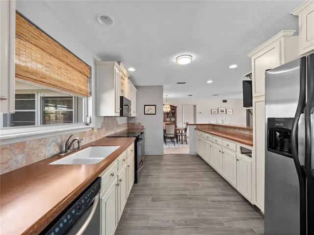 a large kitchen with stainless steel appliances granite countertop a lot of counter space and wooden floors