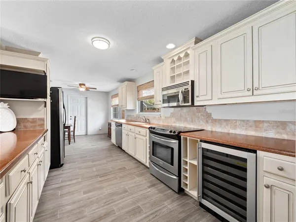 a large kitchen with stainless steel appliances granite countertop lots of counter space and wooden floor