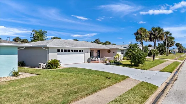 an aerial view of a house with a yard and large tree