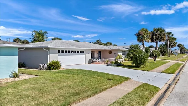 an aerial view of a house with a yard and large tree