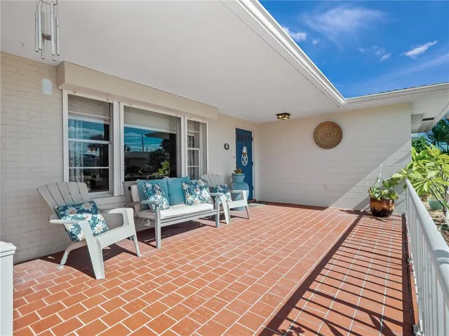 a living room with stainless steel appliances kitchen island a table and chairs