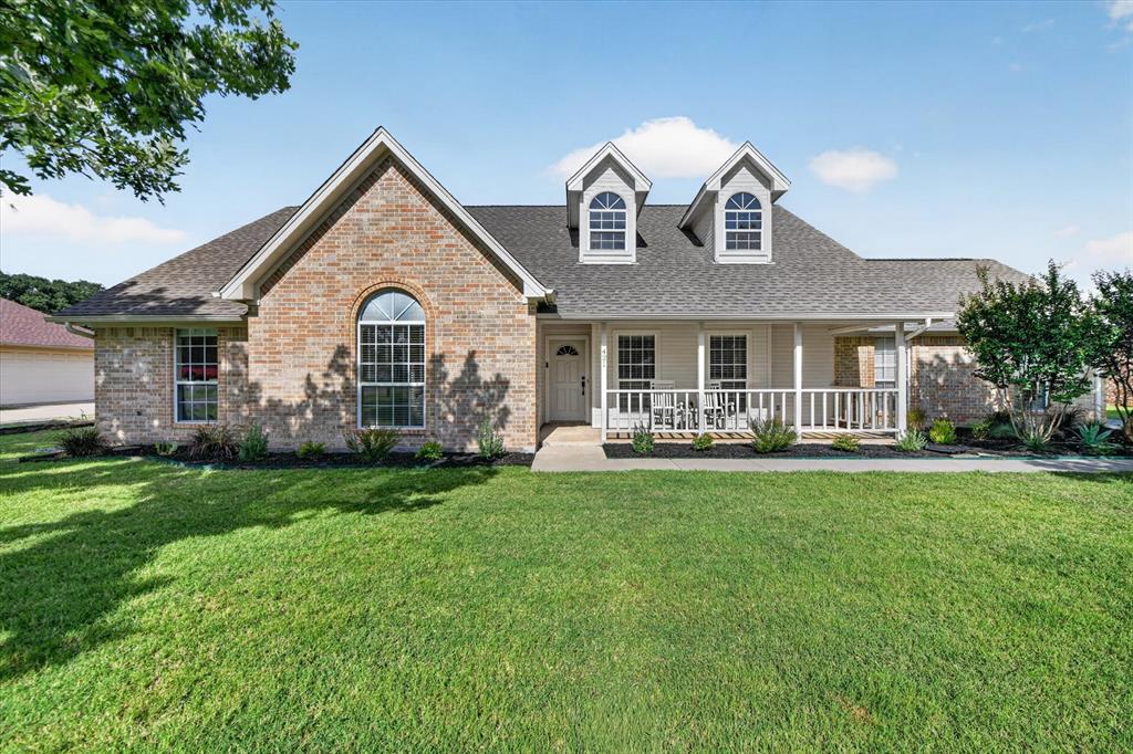 421 Ben Boyd Road Argyle, TX 76226 - Photo 2 of 25 Exterior featuring brick and siding finishes, a covered front porch with white railing, dormer windows, and a manicured lawn