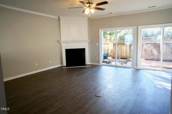 a view of a livingroom with wooden floor a fireplace and window