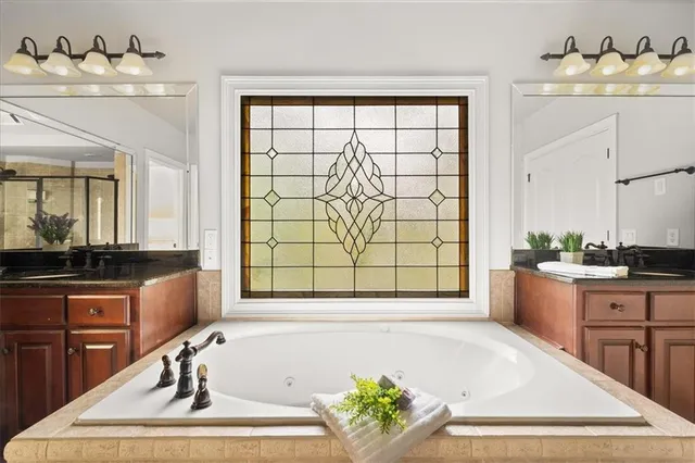 a spacious bathroom with a tub sink and mirror