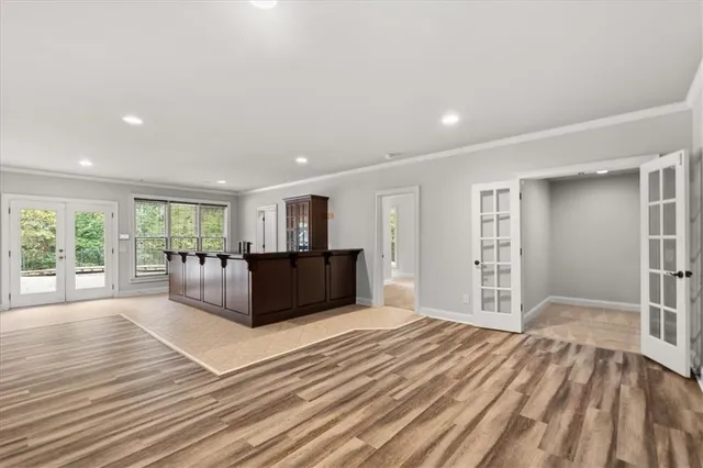 a large bedroom with wooden floor and balcony