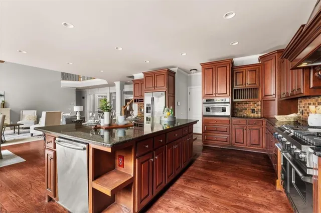a kitchen with stainless steel appliances granite countertop a stove a sink and a refrigerator