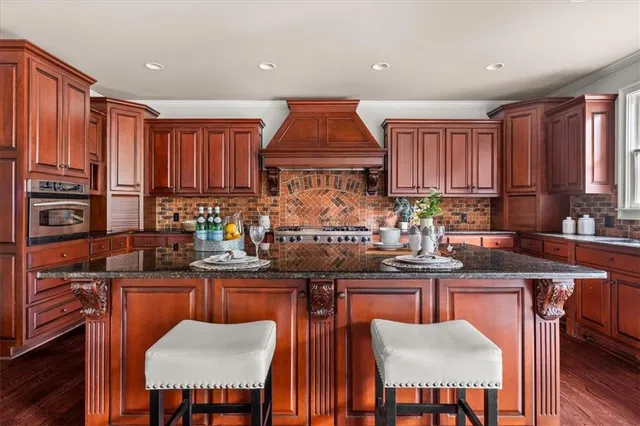 a kitchen with stainless steel appliances granite countertop a stove top oven a sink dishwasher and cabinets