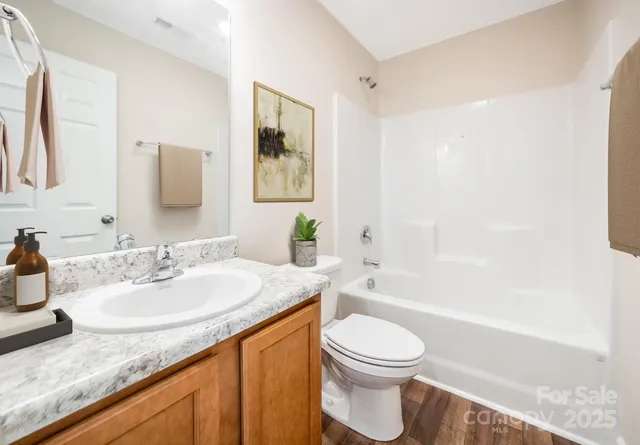 a bathroom with a granite countertop sink a toilet and bathtub