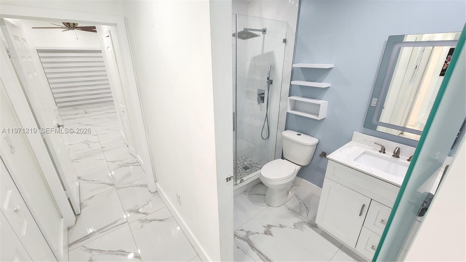 16515 Southwest 97th Street Miami, FL 33196 - Photo 16 of 38 a white toilet sitting next to a bathroom sink and a shower