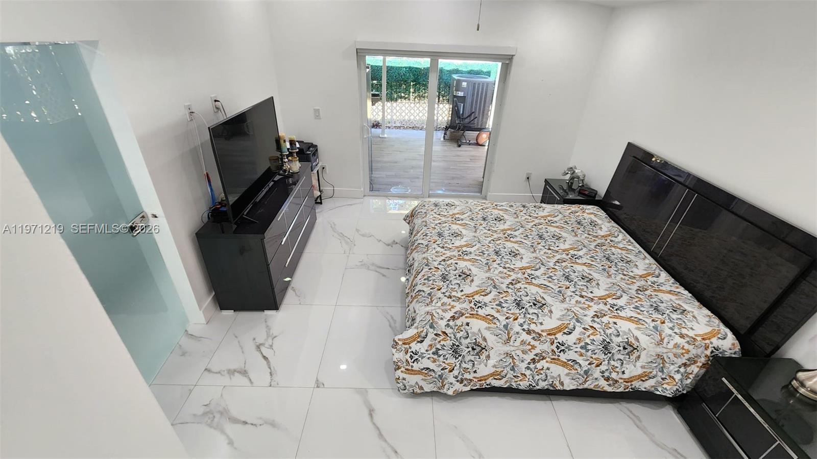 16515 Southwest 97th Street Miami, FL 33196 - Photo 22 of 38 a bed room with a bed tv and a window