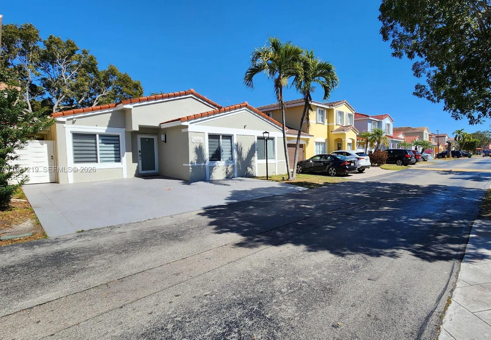 16515 Southwest 97th Street Miami, FL 33196 - Photo 37 of 38 a view of a white house with a yard and palm trees