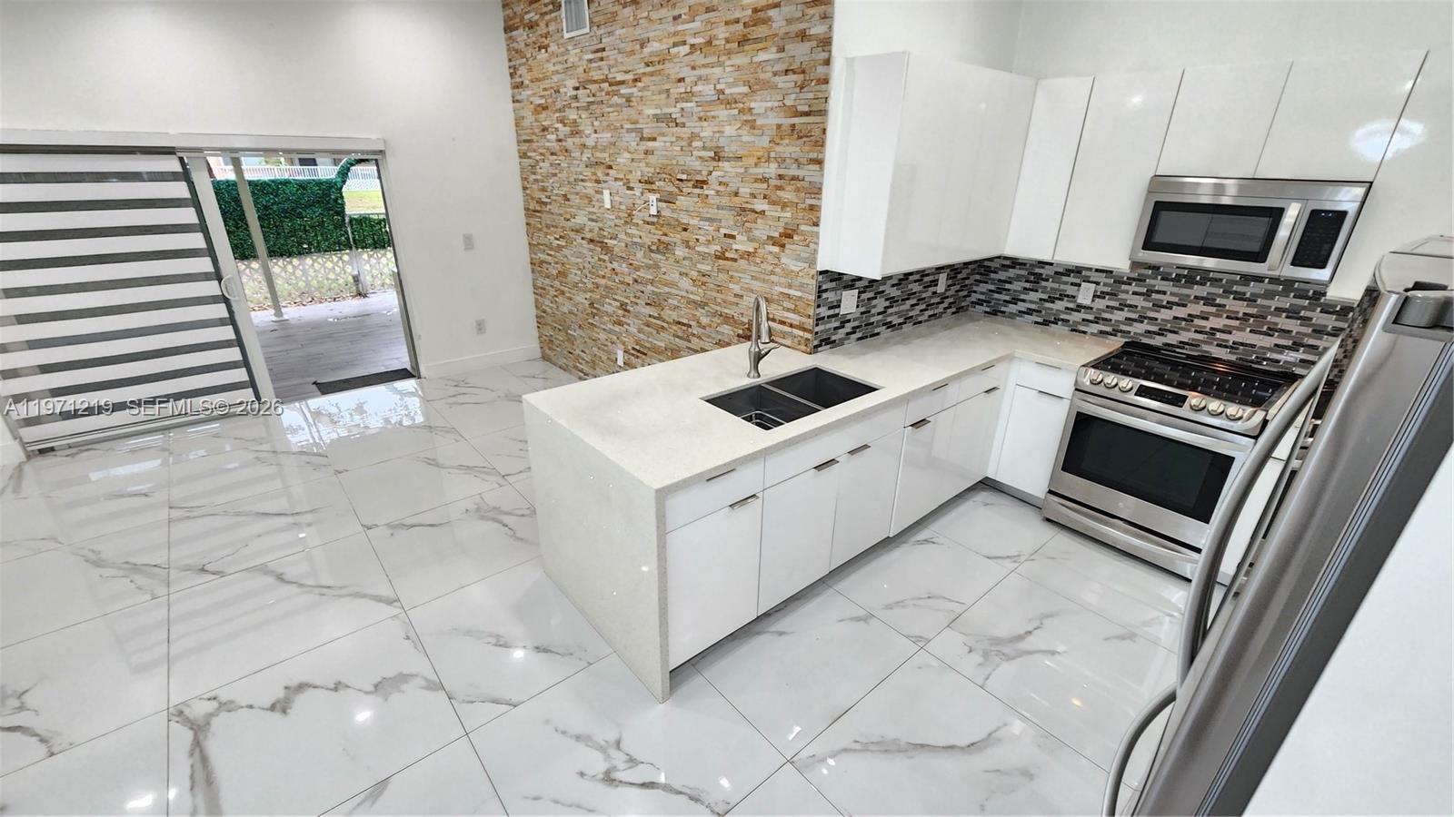 16515 Southwest 97th Street Miami, FL 33196 - Photo 7 of 38 a white kitchen with a stove top oven and sink