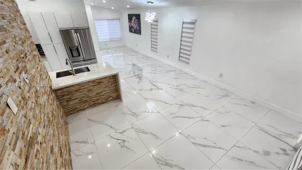 a kitchen with stainless steel appliances kitchen island granite countertop a stove a sink and a microwave