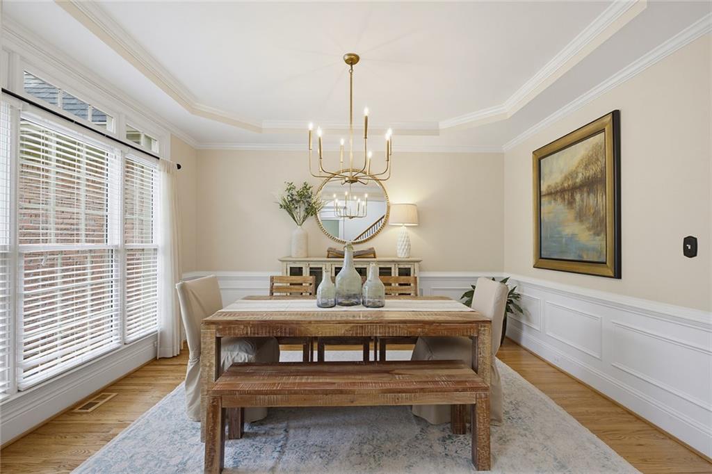 14442 Club Circle Milton, GA 30004 - Photo 22 of 82 a dining room with wooden floor a chandelier a wooden table and chairs