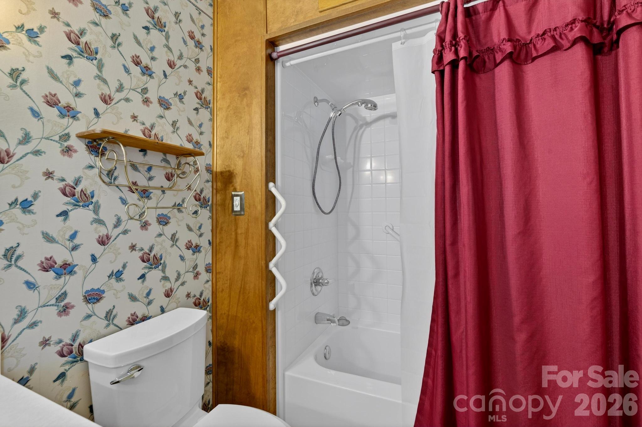 408 Spring Street Northwest Lenoir, NC 28645 - Photo 29 of 47 a bathroom with a shower curtain and a toilet