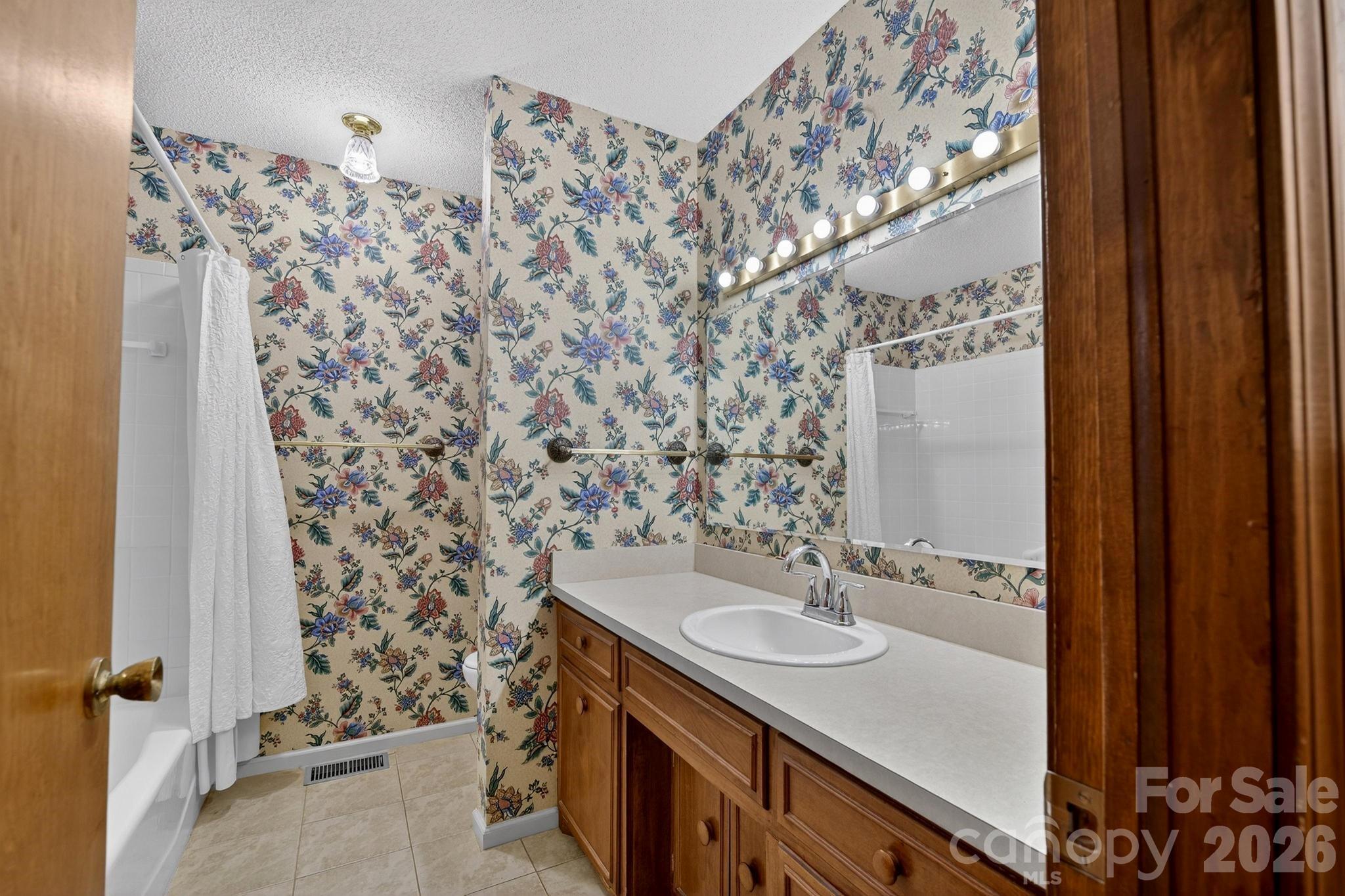408 Spring Street Northwest Lenoir, NC 28645 - Photo 34 of 47 a bathroom with a granite countertop sink a mirror and shower