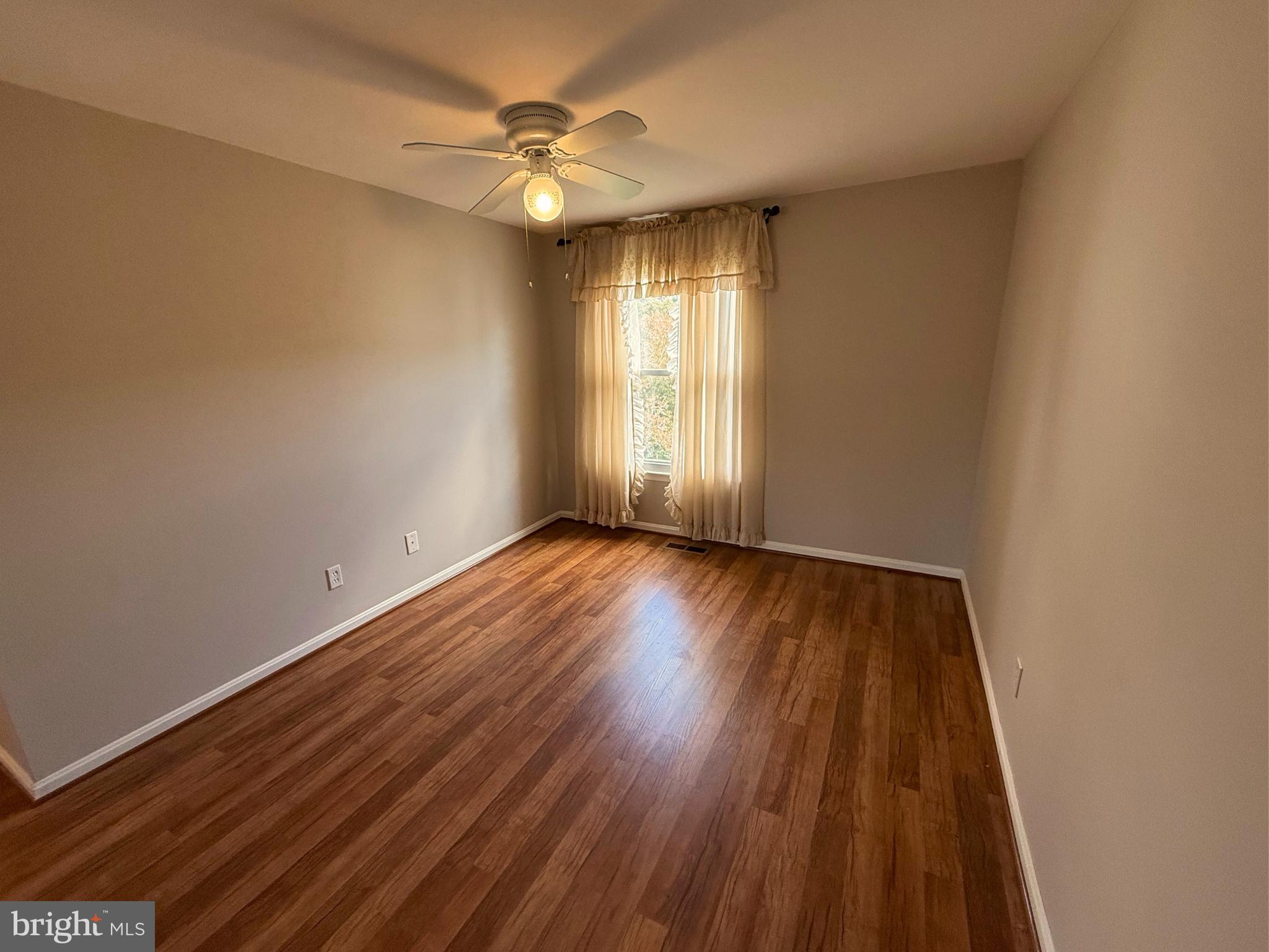 5 Coliston Road, Unit C Reisterstown, MD 21136 - Photo 32 of 39 an empty room with wooden floor and windows