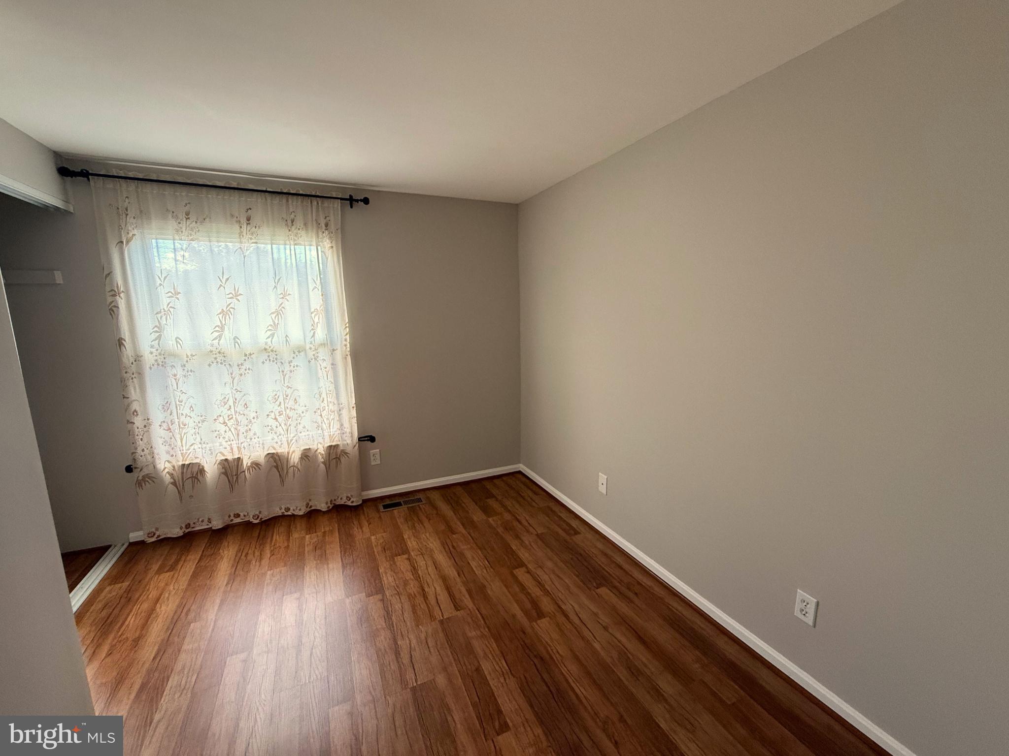 5 Coliston Road, Unit C Reisterstown, MD 21136 - Photo 35 of 39 an empty room with wooden floor and windows