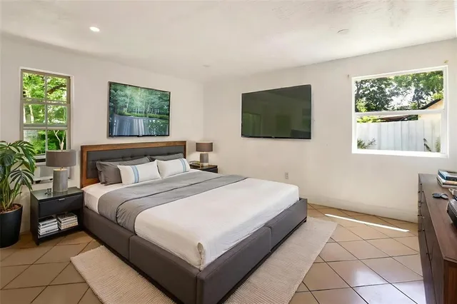 a bedroom with a bed a mirror and a flat screen tv